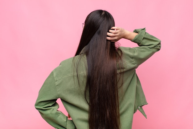 Asian young woman thinking or doubting, scratching head isolated