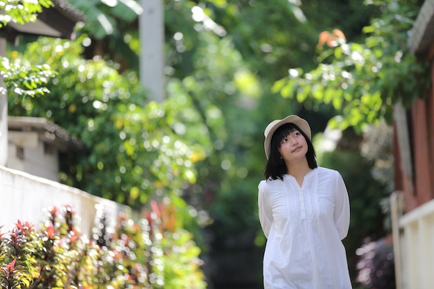 Asian young woman thinking and looking travel concept portrait with green tree background