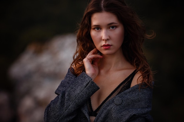 Asian young woman tourist wearing coat in view of mountain against fall forest Girl in underwear wrapped in a gray coat