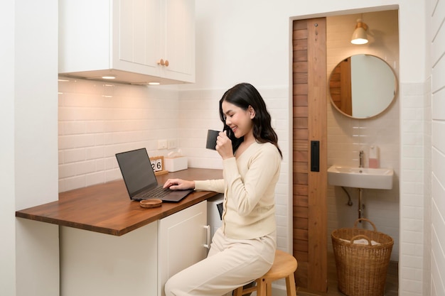 An Asian young woman using laptop computer online working at home lifestyle and teleworking concept