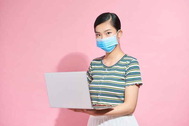 Asian young woman wearing face mask protection working using on laptop