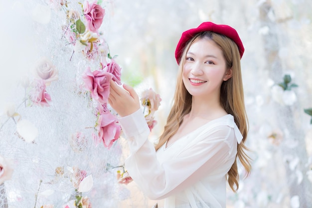 Asian young woman who has blonde long hair wears red cap and white shirt while she holds