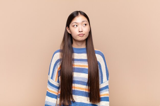 걱정, 혼란, 우둔한 표정으로 아시아 젊은 여자