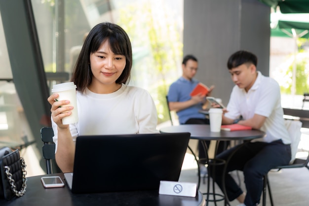 Photo asian young woman working on a laptop