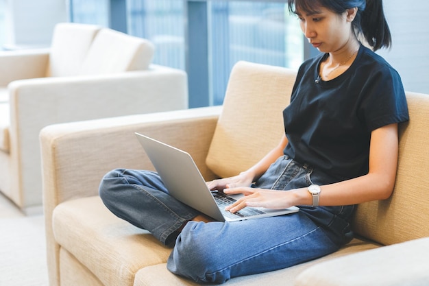 Азиатская молодая женщина, работающая с ноутбуком на дому, внештатная работа