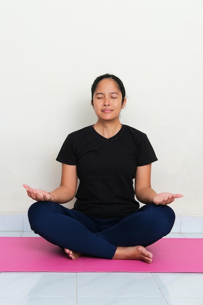 Asian young women doing yoga meditation above sport mattress