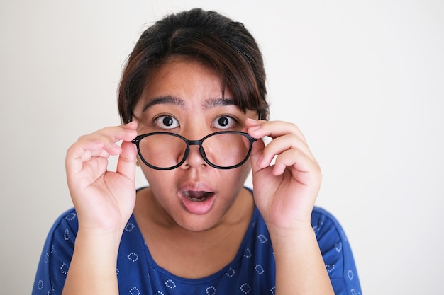 Asian young women showing shocked face expression while taking\
off her eye glasses