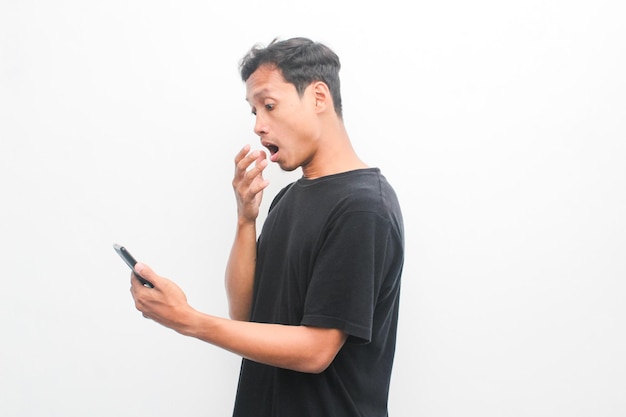 Asian youth with a surprised face looking at the news on his smartphone Advertising model concept