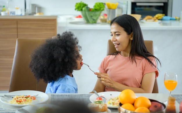 asianafrican american family have a happy meal together in the dining room of the house