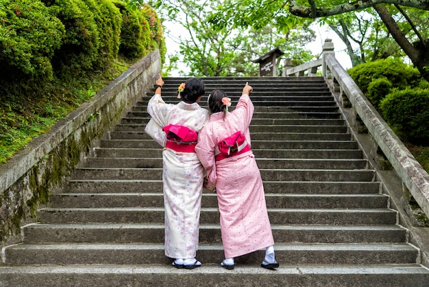 アジアの女性が庭で日本の着物を着ています。