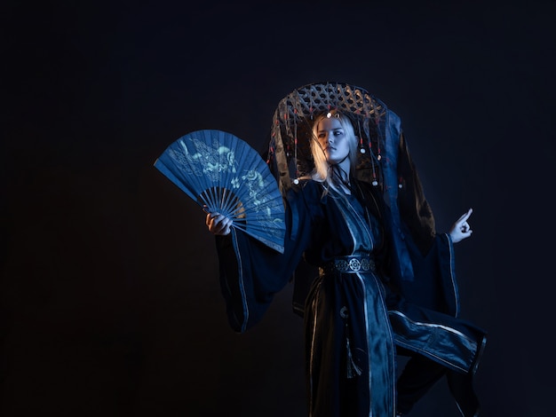 An asianstyle character in a kimono and a straw hat with ribbons