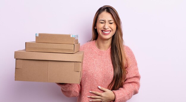 Asiatic pretty woman laughing out loud at some hilarious joke. storage boxes concept