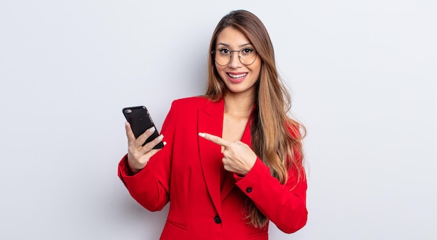 Asiatic pretty woman looking excited and surprised pointing to the side business and phone concept