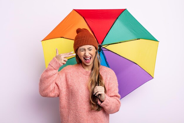 Asiatic pretty woman looking unhappy and stressed, suicide gesture making gun sign. umbrella concept