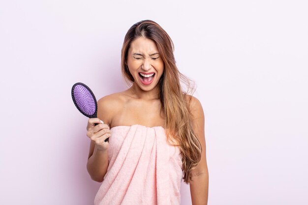 Asiatic pretty woman shouting aggressively, looking very angry. hair care concept