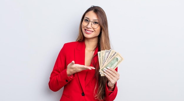 Asiatic pretty woman smiling cheerfully, feeling happy and showing a concept. business and banknotes concept