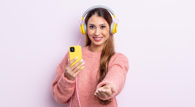 Asiatic pretty woman smiling happily with friendly and  offering and showing a concept. headphones and phone concept