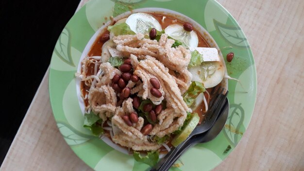 Asinan pickled vegetables or fruits dish served with peanut sauce fried peanuts and rice crackers from Indonesia