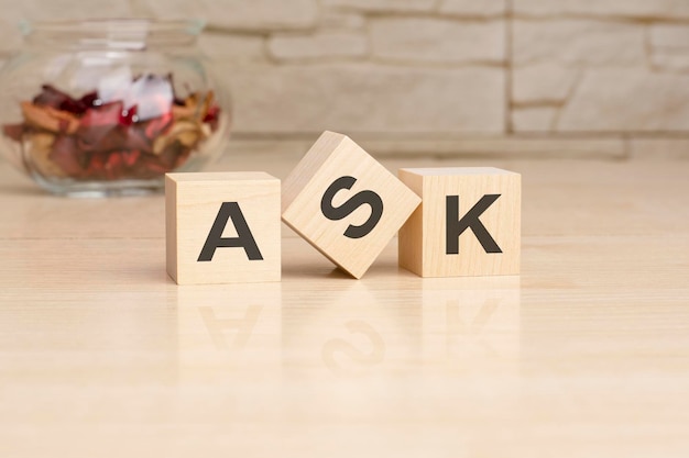 ASK acronym from wooden blocks with letters top view on grey background