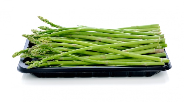 Asparagus in black plastic tray on a white background