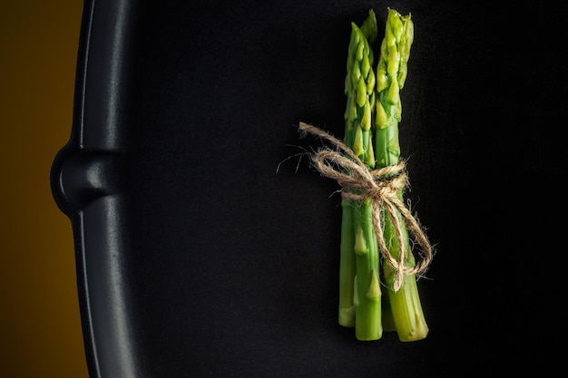 Фото Спаржа куча свежих зеленых спаржи привязана к сковородке здоровая вегетарианская еда