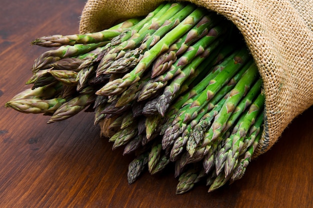 Asparagus in burlap sack on wood