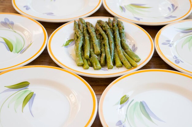 Asparagus by empty plates on table