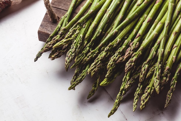 Asparagi su un tagliere su un vecchio sfondo bianco