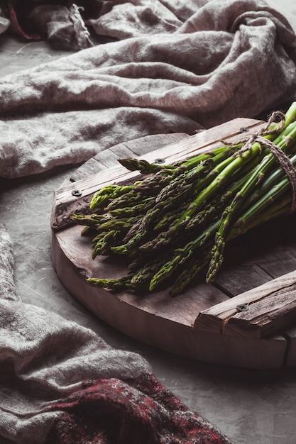 Asparagus on a cutting board. Healthy food, health on a concrete background.