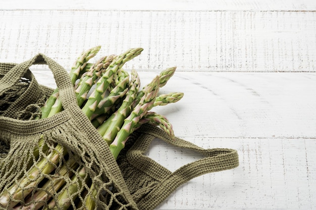 Asparagus. Fresh green asparagus bunch ready for cooking on white old wooden background. Top view copy space.