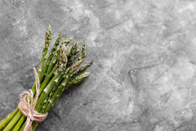 Asparagus. Fresh green asparagus on grey rustic background. Top view copy space. Bunches of green asparagus