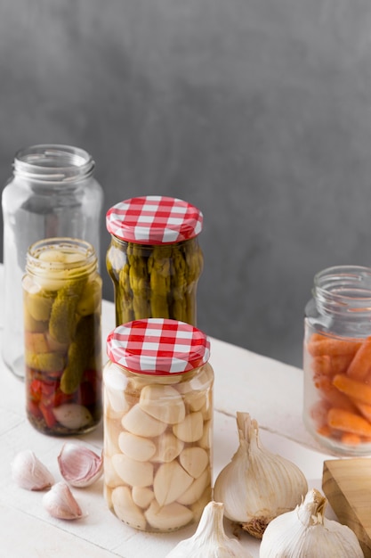 Photo asparagus, garlic and olives preserved in glass jars