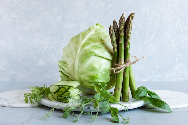 Asparagus, microgreens, cucumber and cabbage are fresh green vegetables.