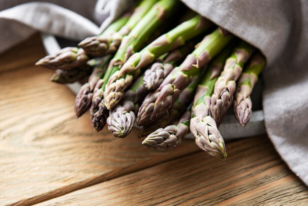 Asparagi sulla vecchia superficie di legno. preparazione del cibo. cibo salutare.