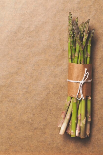 Asparagus tied in a bunch on a rustic brown paper background