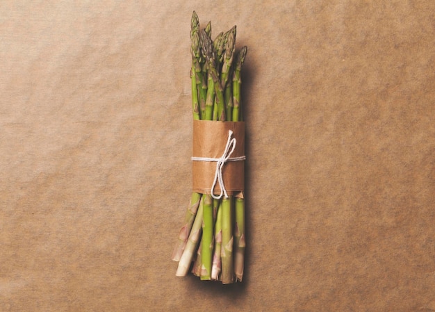 Asparagus tied in a bunch on a rustic brown paper background