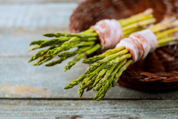 Asparagus with rolled in bacon, on a wooden background, rustic style