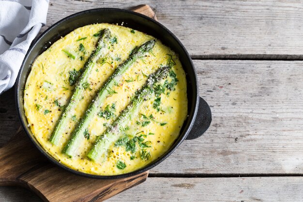 Asparagus with scrambled eggs. omelet with asparagus in a\
frying pan.