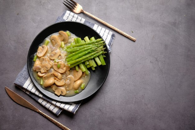 Asperges groene olijfolie en paddestoel op plaat zwarte achtergrond