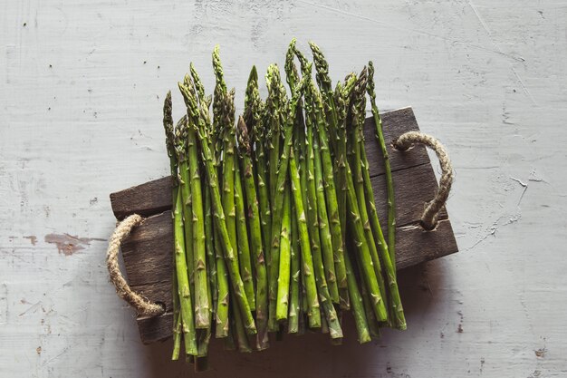 Asperges op een gesneden bord op een oude witte achtergrond