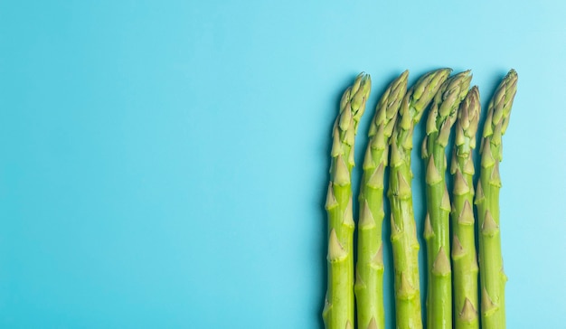 Asperges op een witte plaat op een blauwe ondergrond