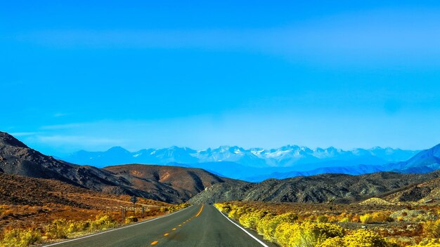 asphalt blue sky road natural scenery snow mountain