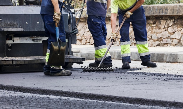 Foto asfalto negli operatori della città che lavorano con strumenti e uniforme