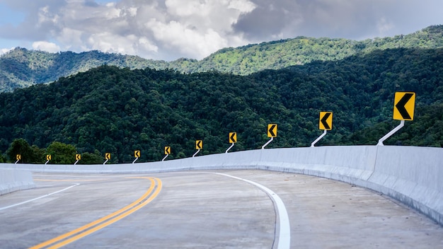 写真 霧深い山を背景に田舎のアスファルトカーブ道路