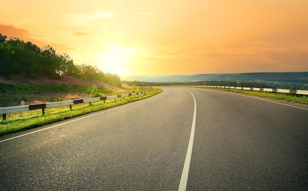 Foto autostrada asfaltata contro il cielo giallo tramonto