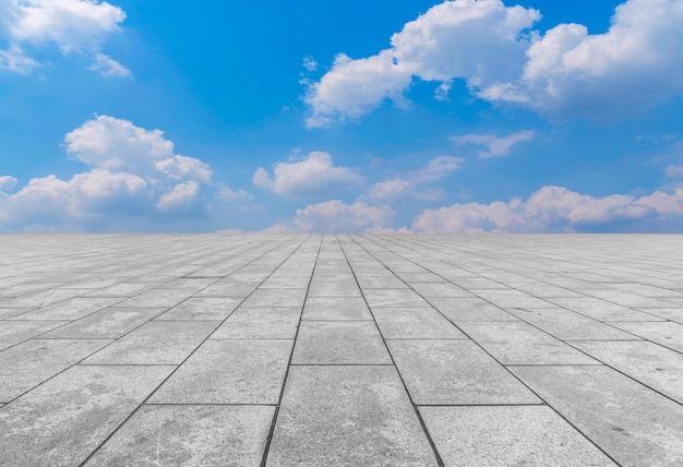 Asphalt pavements and square floor tiles under the blue sky and white clouds