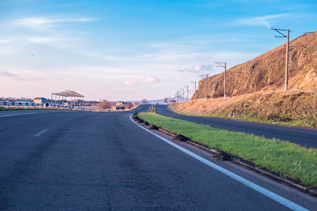 Asphalt road field and clouds on blue sky in summer day