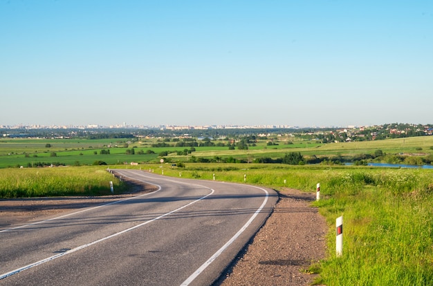 Photo asphalt road in the green fields panorama