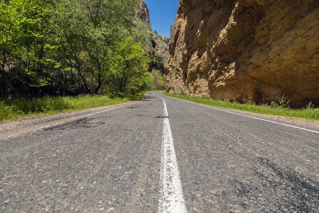 Asphalt road and rocks in the sunny day