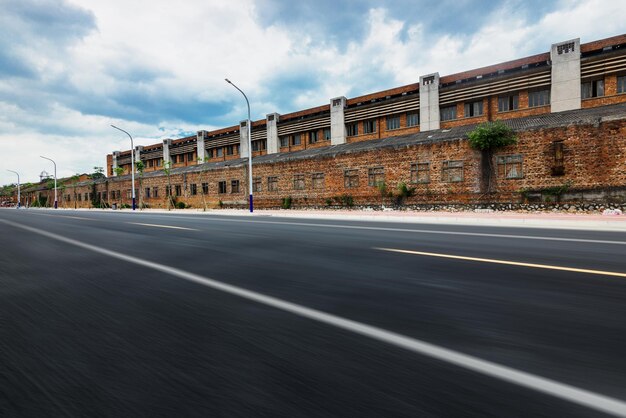 The asphalt road straight ahead of the old redbrick building